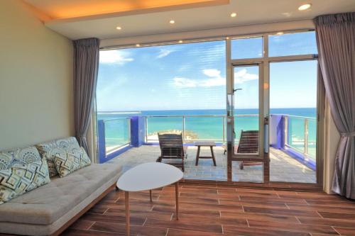 a living room with a couch and a view of the ocean at Two Home Inn in Hualien City