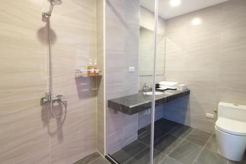 a bathroom with a shower with a toilet and a sink at Two Home Inn in Hualien City