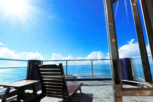 a chair on a balcony with a view of the ocean at Two Home Inn in Hualien City