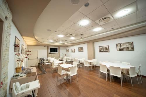 a dining room with white tables and white chairs at Ibis Styles Palermo Cristal in Palermo