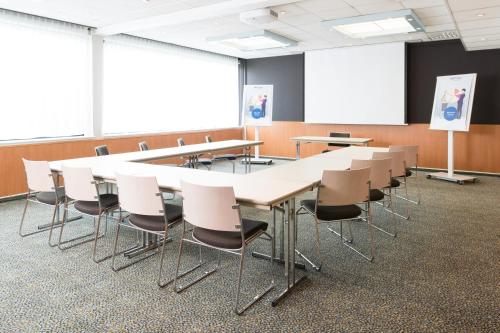 a conference room with a long table and chairs at Novotel Brussels Airport in Diegem