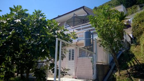 a white house with a gate and trees at Apartmani "Srma" Srma 2 in Herceg-Novi