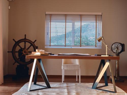a desk with a wheel in a room with a window at Serenus Luxury Villa in Keri