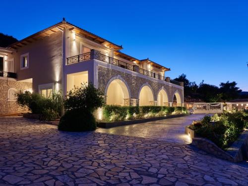a villa with a courtyard at night at Serenus Luxury Villa in Keri