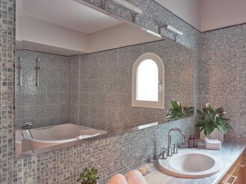 a bathroom with a tub and a sink at Serenus Luxury Villa in Keri
