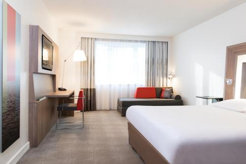 a hotel room with a bed and a couch at Novotel Brussels Airport in Diegem