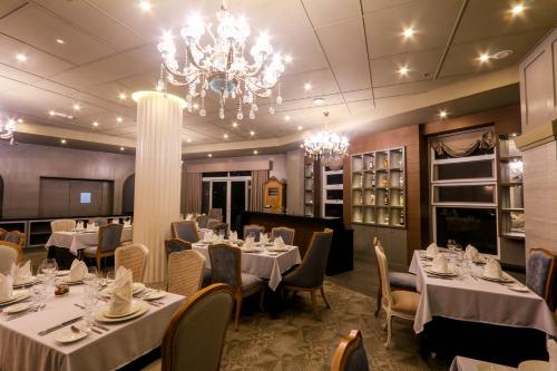 a dining room with tables and chairs and a chandelier at Hotel Carlito Tagaytay in Tagaytay