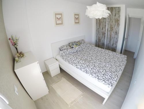 ベナルマデナにあるCasa de Mariposasの白い小さなベッドルーム(ベッド1台、シャンデリア付)