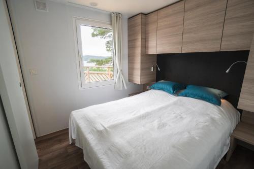 ユシーレにあるAnfasteröd Gårdsvik - Örnnästetのベッドルーム(青い枕の大きな白いベッド付)