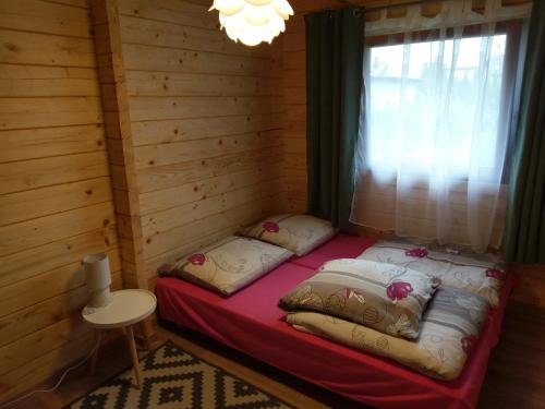Ένα ή περισσότερα κρεβάτια σε δωμάτιο στο Domki Żabi Staw
