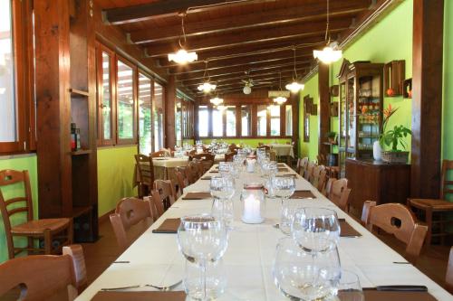 ノーヴァ・シーリ・マリーナにあるAzienda Agrituristica Il Pagoのワイングラス付きレストランの長テーブル