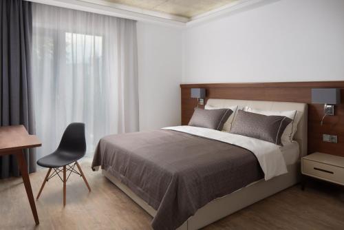 a bedroom with a bed and a desk and a chair at JBX Resort Apartments Lipno in Lipno nad Vltavou