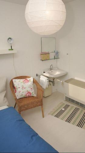 a bathroom with a wicker chair and a sink at Ferienhaus Schwärzer in Bischofsgrün