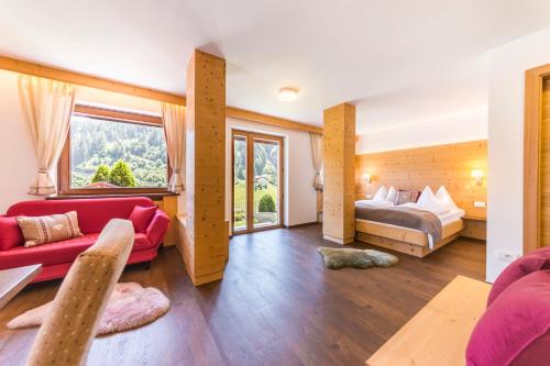 un soggiorno con letto e divano di Apartments Mezdi a Santa Cristina in Val Gardena