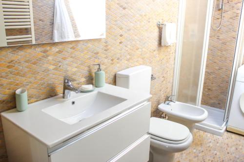 a white bathroom with a toilet and a sink at Sant'Agata in Ravenna