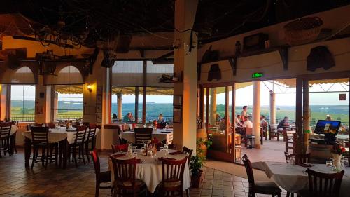 a restaurant with tables and chairs and people in the background at Seven Generations Winery Hotel in Mechka