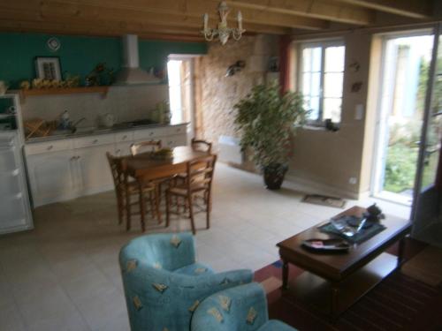 une cuisine et un salon avec une table et des chaises dans l'établissement Le Bukarou, à Saint-Léon-dʼIssigeac