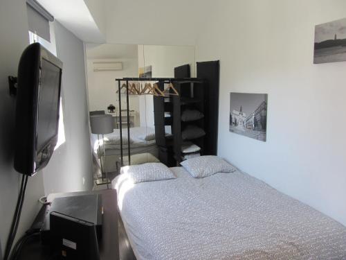 リスボンにあるHouse Mourariaのベッドルーム(ベッド1台、薄型テレビ付)