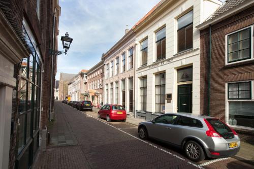 two cars parked on a city street with buildings at Stadslogement Bij de Sassenpoort in Zwolle