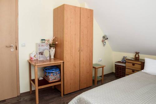プリモルスコにあるLaguna Penthouseのベッドルーム1室(ベッド1台付)、木製キャビネットが備わります。