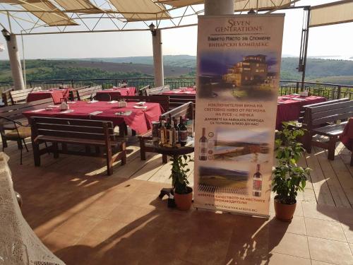 a sign for a restaurant with tables and chairs at Seven Generations Winery Hotel in Mechka
