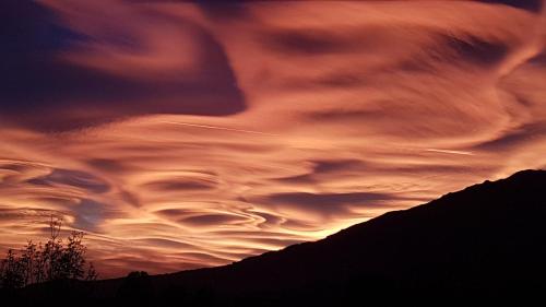 a cloudy sky at sunset with a mountain at B&B Villa Tavallini in Pollone