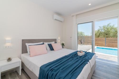 a bedroom with a large bed and a swimming pool at Maridenia Villa in Lithakia