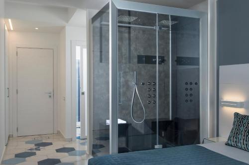 a bathroom with a shower and a bed in a room at Lloyd's Baia Hotel in Vietri sul Mare