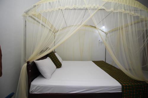 a bed with a canopy in a room at Bentota Home Stay in Bentota