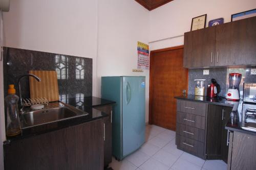 a kitchen with a blue refrigerator and a sink at Bentota Home Stay in Bentota