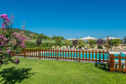 a wooden fence in a yard with a pool at Relais Paradiso Resort & Spa in Gualdo Cattaneo