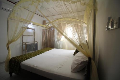 a bedroom with a bed with a canopy at Bentota Home Stay in Bentota