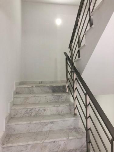 a staircase with marble floors and a black rail at Rasi Luxury Apartments in Ulcinj