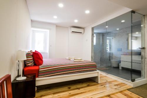 - une chambre avec un lit et une douche en verre dans l'établissement Casa Touriga 129, à Lisbonne