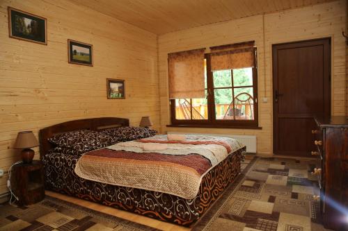 a bedroom with a bed in a wooden room at Zarinok in Pilipets