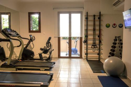 a gym with treadmills and exercise bikes in a room at Aristea Hotel in Rethymno Town