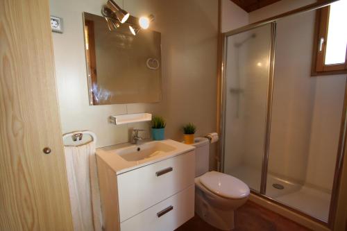 a bathroom with a toilet and a sink and a shower at Camping Joan Bungalow Park in Cambrils