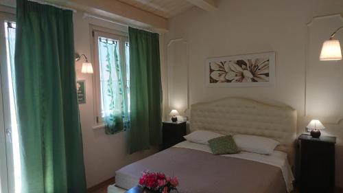 1 dormitorio con 1 cama con cortinas verdes en Il Piccolo Giglio, en Porto SantʼElpidio