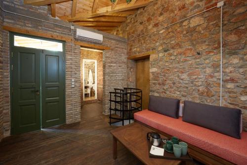 a living room with a green door and a brick wall at Athenian Residences in Athens
