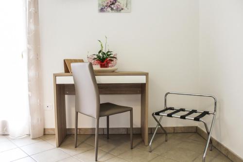 a table with a chair and a plant on it at B&B al Doremi in Castegnero