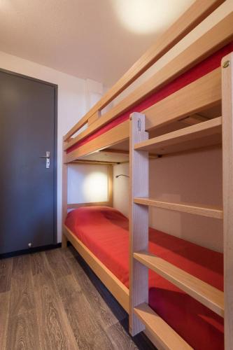 - une chambre avec 2 lits superposés et un lit rouge dans l'établissement Vacanceole - Résidence Andromede, à Les Deux Alpes