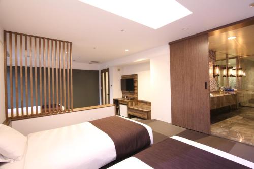 a hotel room with a bed and a bathroom at Quintessa Hotel Sapporo in Sapporo