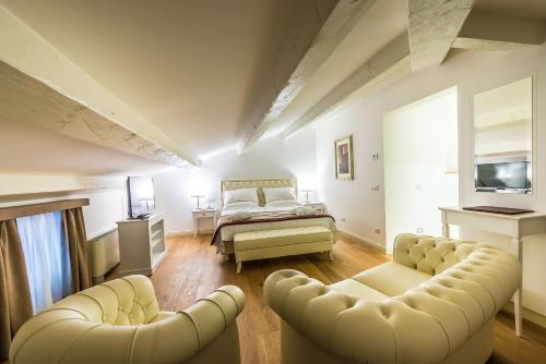 a bedroom with a bed and two couches at Relais Paradiso Resort & Spa in Gualdo Cattaneo