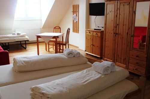 a room with two beds and a table with a table at Gasthof zum Goldenen Rössl in Sachsenburg