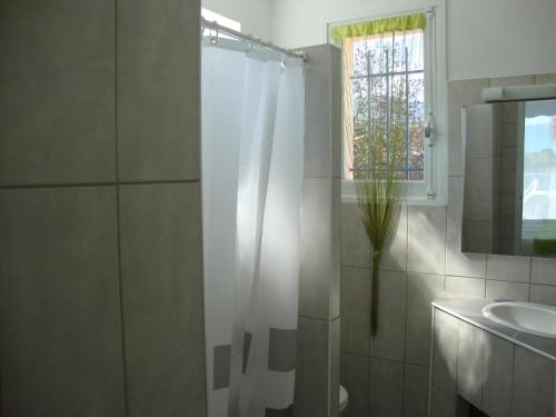 a bathroom with a shower curtain and a sink at Hotel Le Golfe Bleu in Cavalaire-sur-Mer