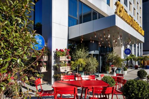 デュッセルドルフにある25hours Hotel Das Tourの建物前の赤いテーブルと椅子