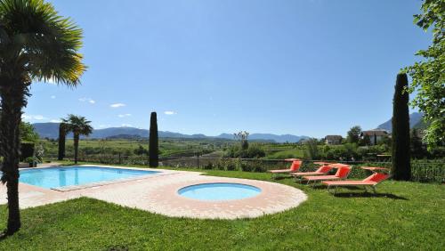 una piscina con tumbonas y una palmera en Garni Luziafeld Hof, en Appiano sulla Strada del Vino