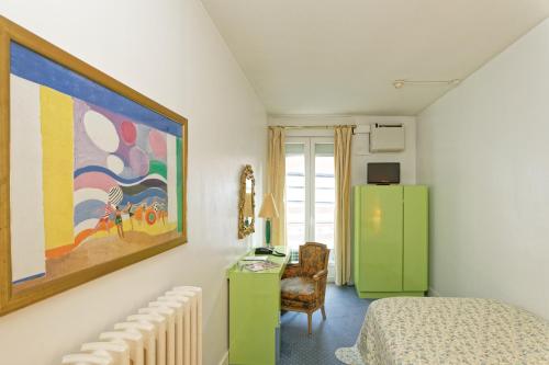 Hostel Toulouse Wilson في تولوز: غرفة نوم مع ثلاجة خضراء ومكتب