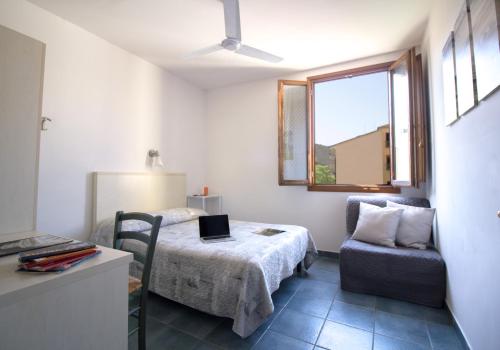 フィレンツェにあるイル ギーロ ゲスト ハウスのベッドルーム1室(ベッド1台、椅子、窓付)