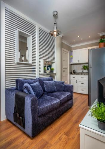 a living room with a blue couch in a kitchen at Sodic Westown Residence1-near Elnada hospital in ‘Izbat Yūsif Barrādah